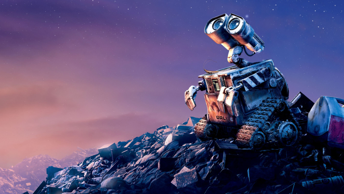 WALL-E perched on a garbage heap, looking up at the sky.